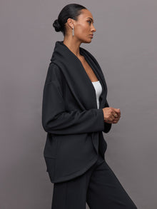 Model wears black open-front cardigan with a loose, draped fit, wide bell sleeves, and side pockets.