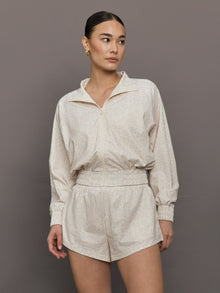 Model wears lightweight windbreaker with a snow leopard print, front zipper, and collared neck.




