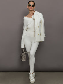 Model wears a white v neck bell sleeved sweater. 