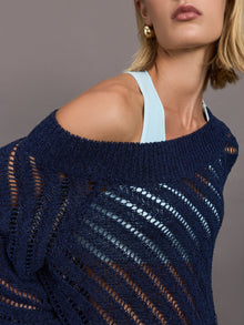 Model wears a navy off shoulder mesh cardigan with diagonal pattern. 
