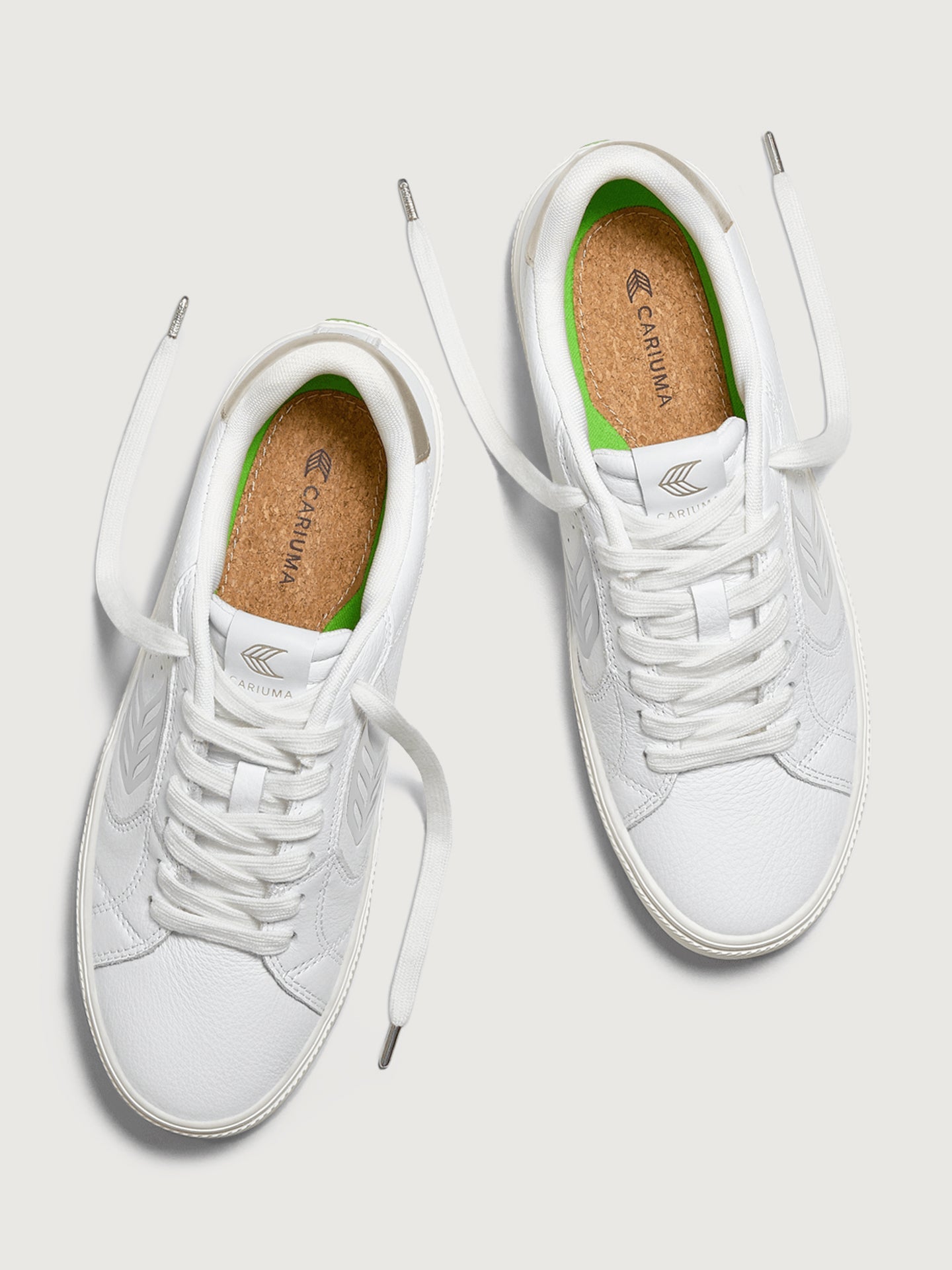 White sneaker with metallic gold heel and leaf logo on side. 