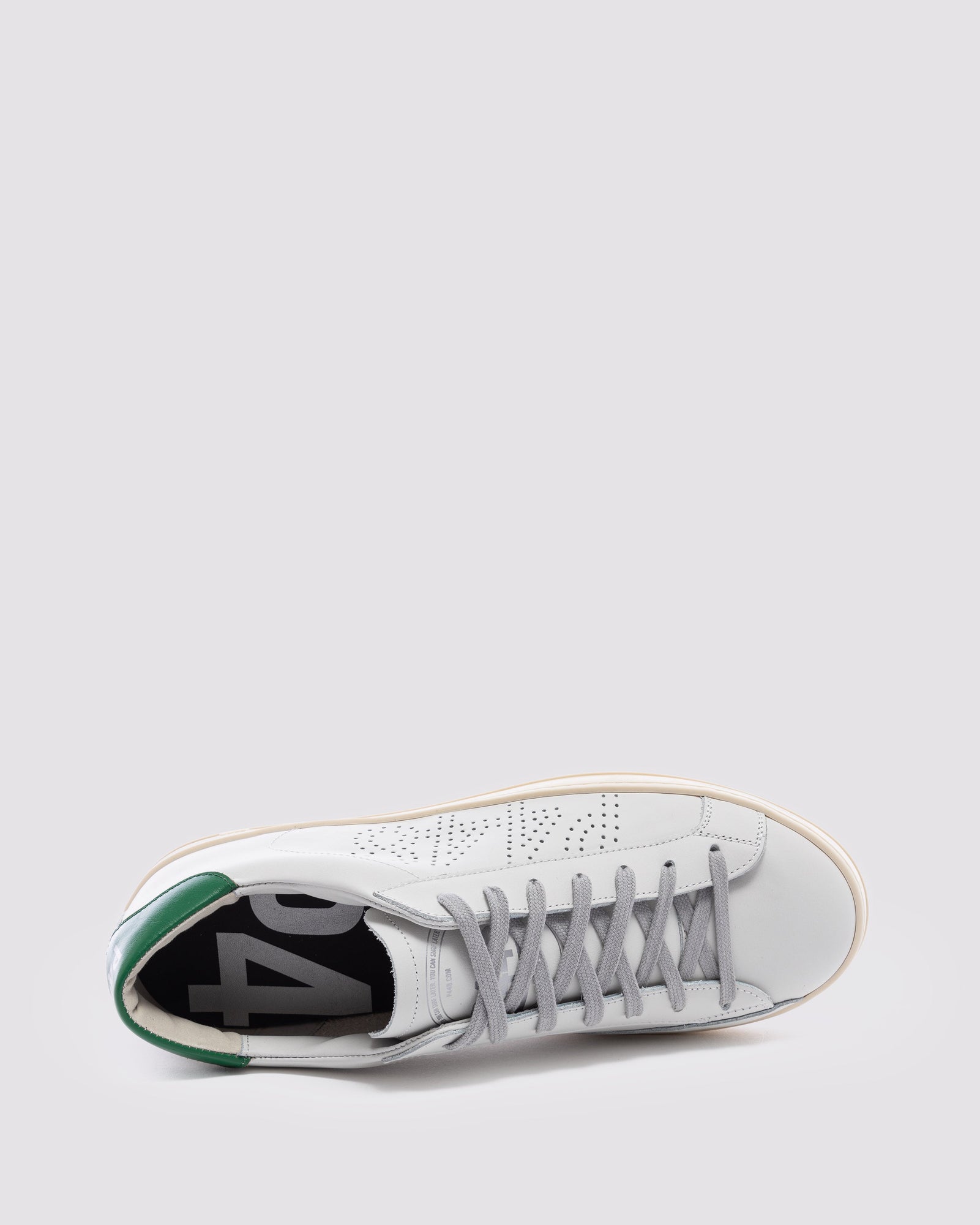 Side angle of white and  green sneakers