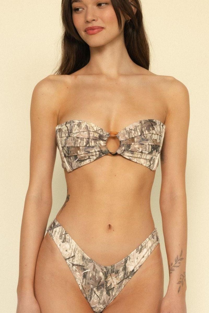 Camo print bikini bottom with zig-zag stitch detailing and high-cut legs on model.
