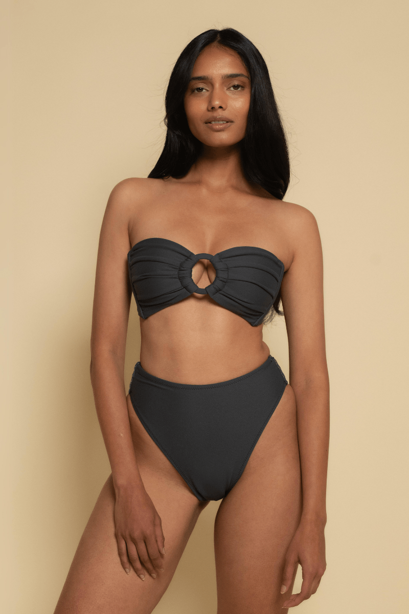 Charcoal bikini bottom with high-waisted cut and moderate coverage on model against neutral background.