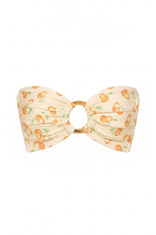 Cream bandeau bikini top with orange cherry and green leaf print, gold ring detail at center.