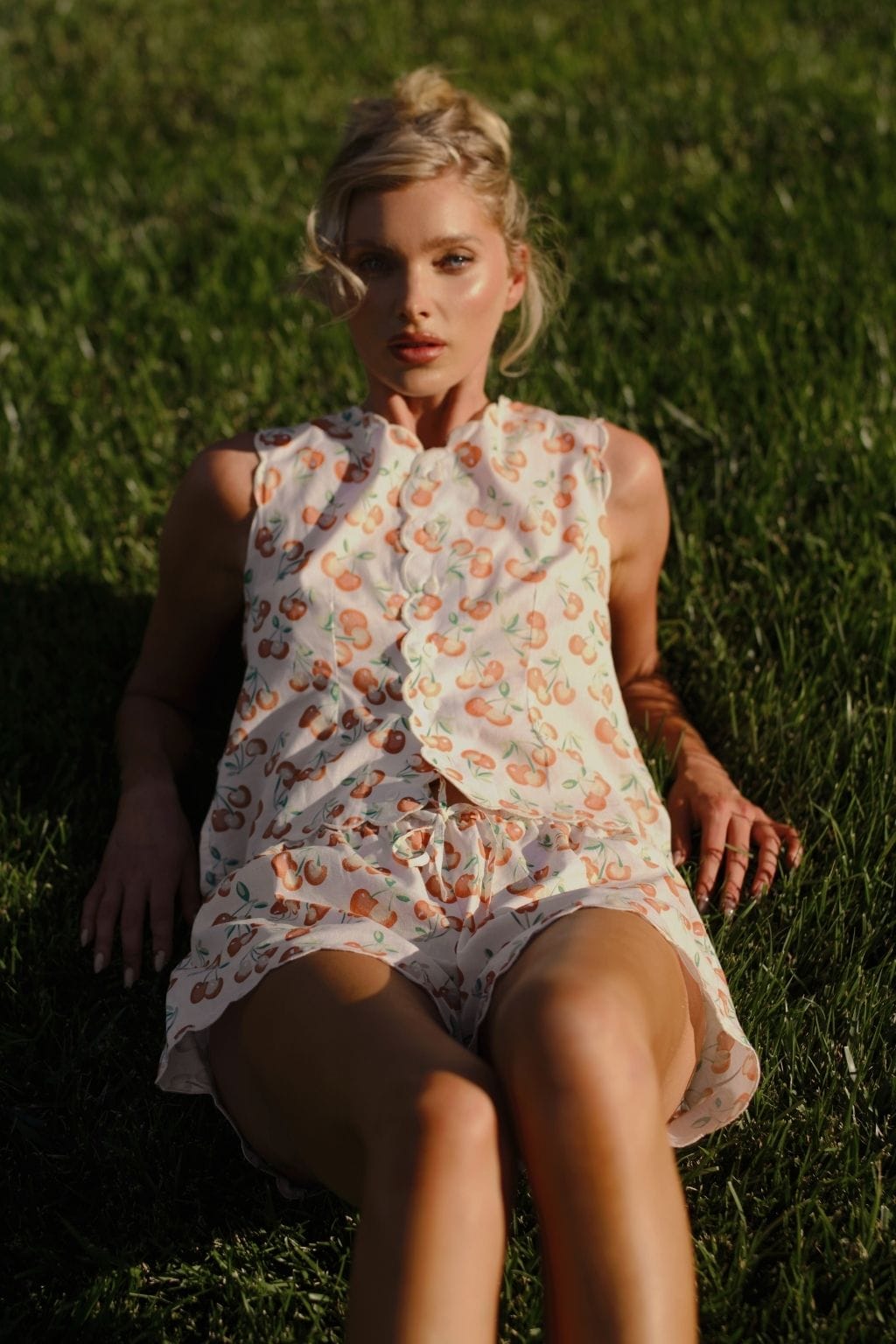 Sleeveless cream vest with orange cherry print and scalloped edges worn over matching shorts.