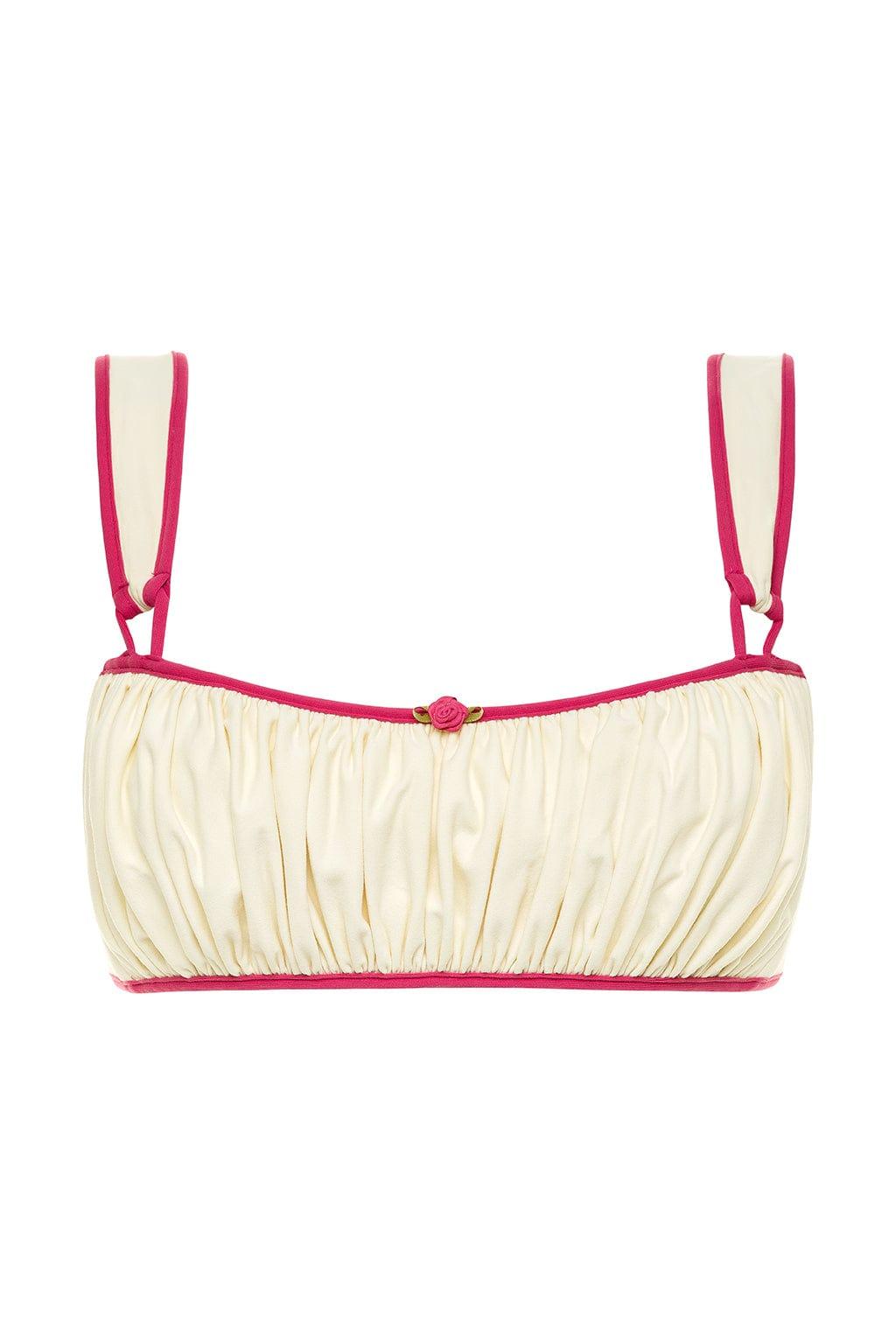 Cream bikini top with raspberry pink binding, gathered fabric, and adjustable shoulder straps with center rose detail.