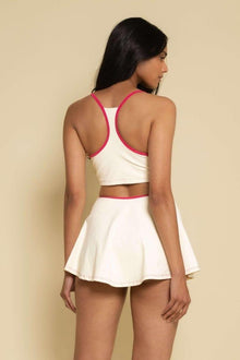 Cream racerback sport top with raspberry binding and matching waistband, shown from back.