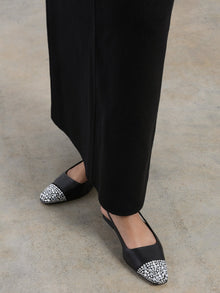 Black leather slingback flat with a sharp square-toe and crystals on the cap.