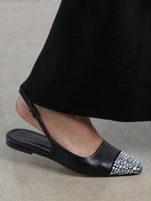 Black leather slingback flat with a sharp square-toe and crystals on the cap.