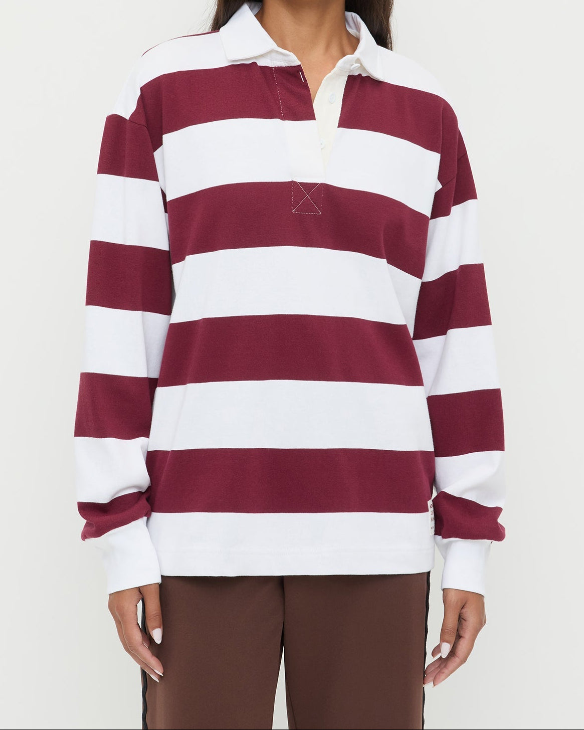 Evan Rugby Shirt in maroon and white striped cotton and Venus Track Pant in brown cotton.