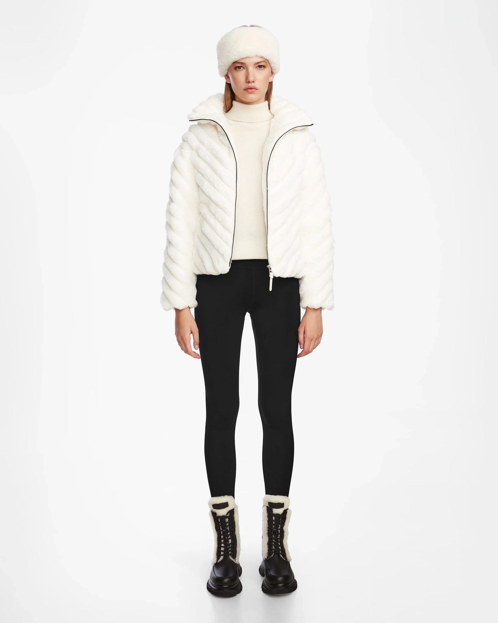 A woman wears the Rudsak ANASTASIA - 8124804 Iceland womens down puffer in white, styled elegantly with a matching hat.