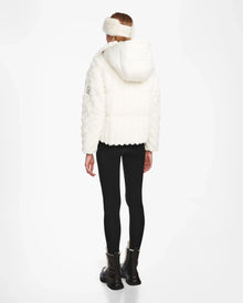 A woman wearing a white Rudsak ANASTASIA - 8124804 Iceland coat with RDS-certified down and black pants.