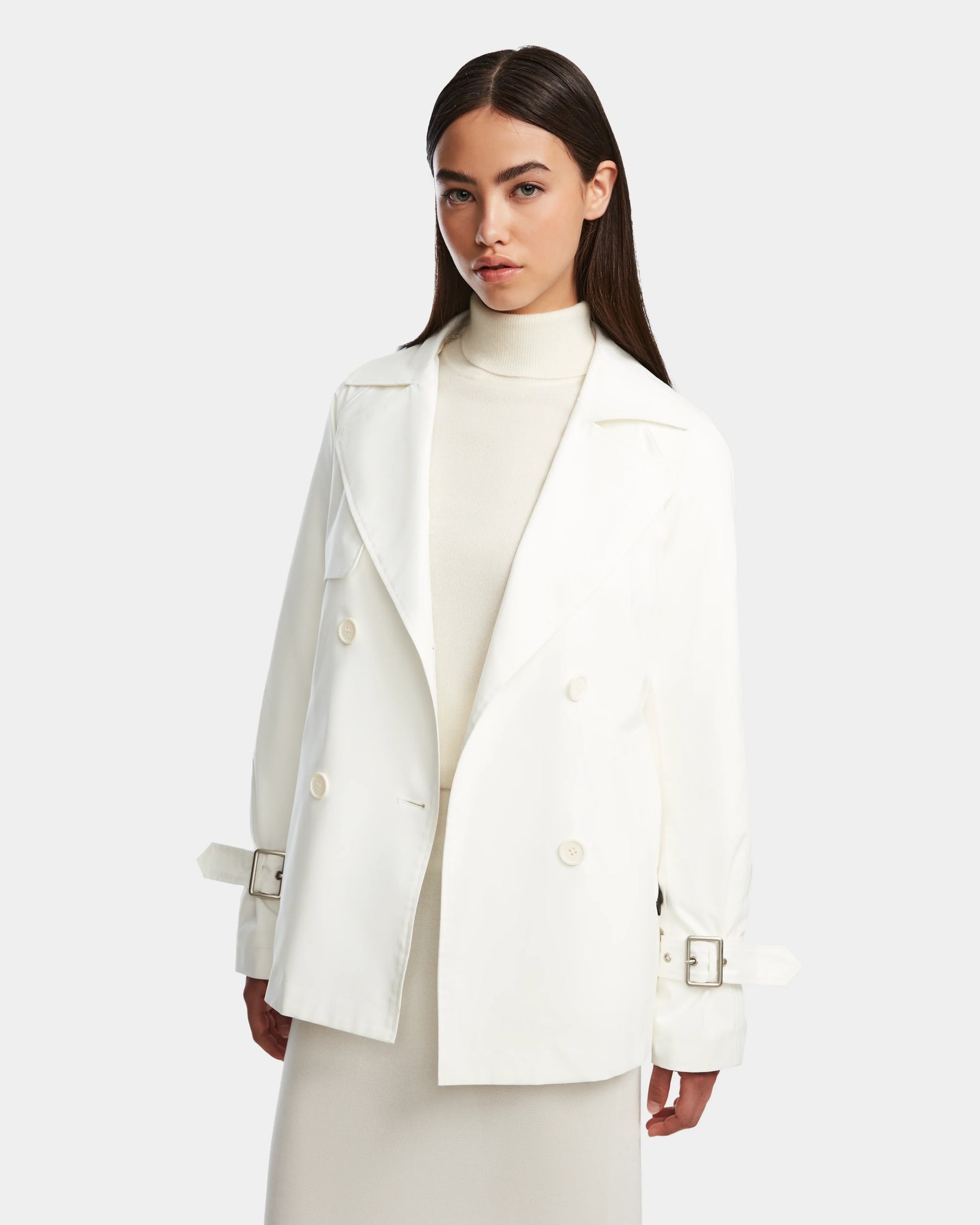 A woman stands confidently in the Rudsak ELENOR - 8124707 Iceland trench coat with a shearling collar, embodying effortless style and elegance.