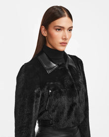 A woman wearing the EVELYN - 8124791 Black faux fur jacket by Rudsak.