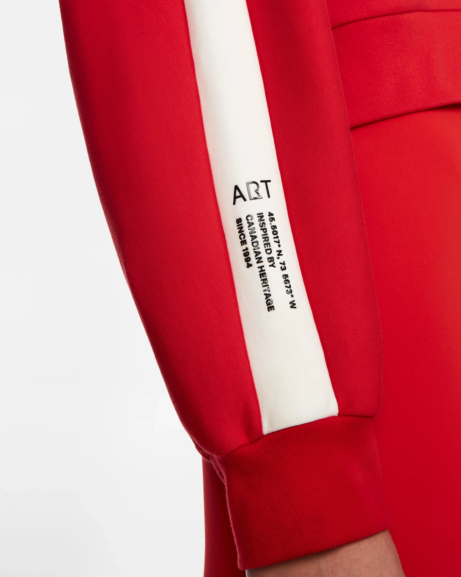 Close-up of a woman wearing the Rudsak KELLIE - 8524615 Flame Red relaxed fit top with a white stripe featuring black ART text and printed details, crafted from comfortable scuba fabric.