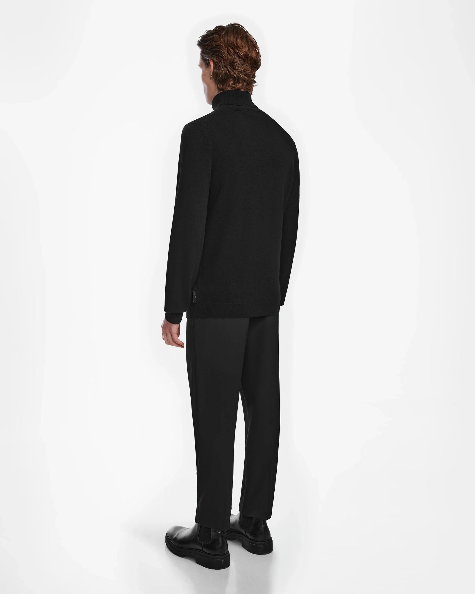 A man in a sleek black ensemble featuring the Rudsak NICOLAS - 6524528 cashmere turtleneck, radiating modern luxury and effortless style.