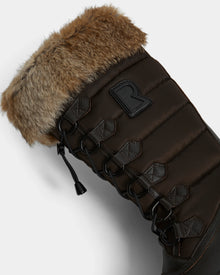 Close-up of Rudsak’s WINDY - L224507 Espresso womens winter boot in dark brown, with black laces, metal eyelets, faux fur trim, and a stitched R logo on the padded side for cozy cold-weather style.