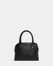 A black womens leather tote bag, the YASMINA - 8324527 by Rudsak, features two rounded handles and a smooth, minimalist design. The tote is displayed on a light gray surface against a plain background.