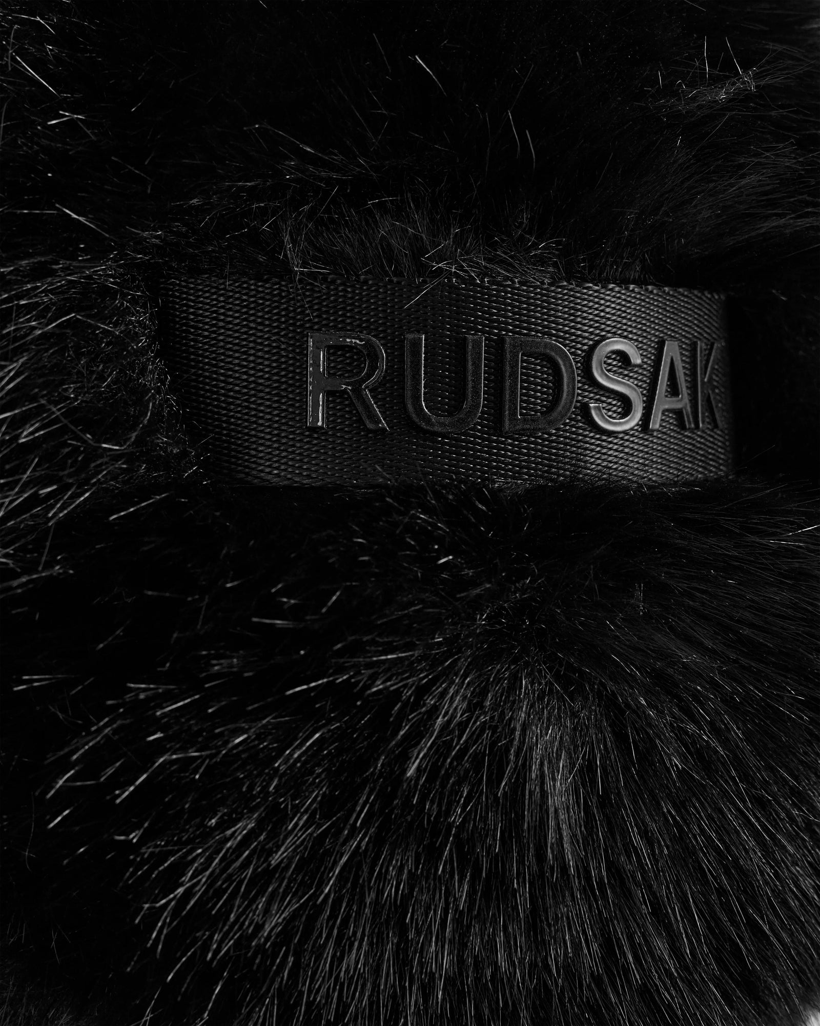A close-up of the black faux fur and embossed Rudsak band on the DEMI - L425539 Black highlights the luxe detail of this women’s aviator hat—a stylish and cozy winter choice.