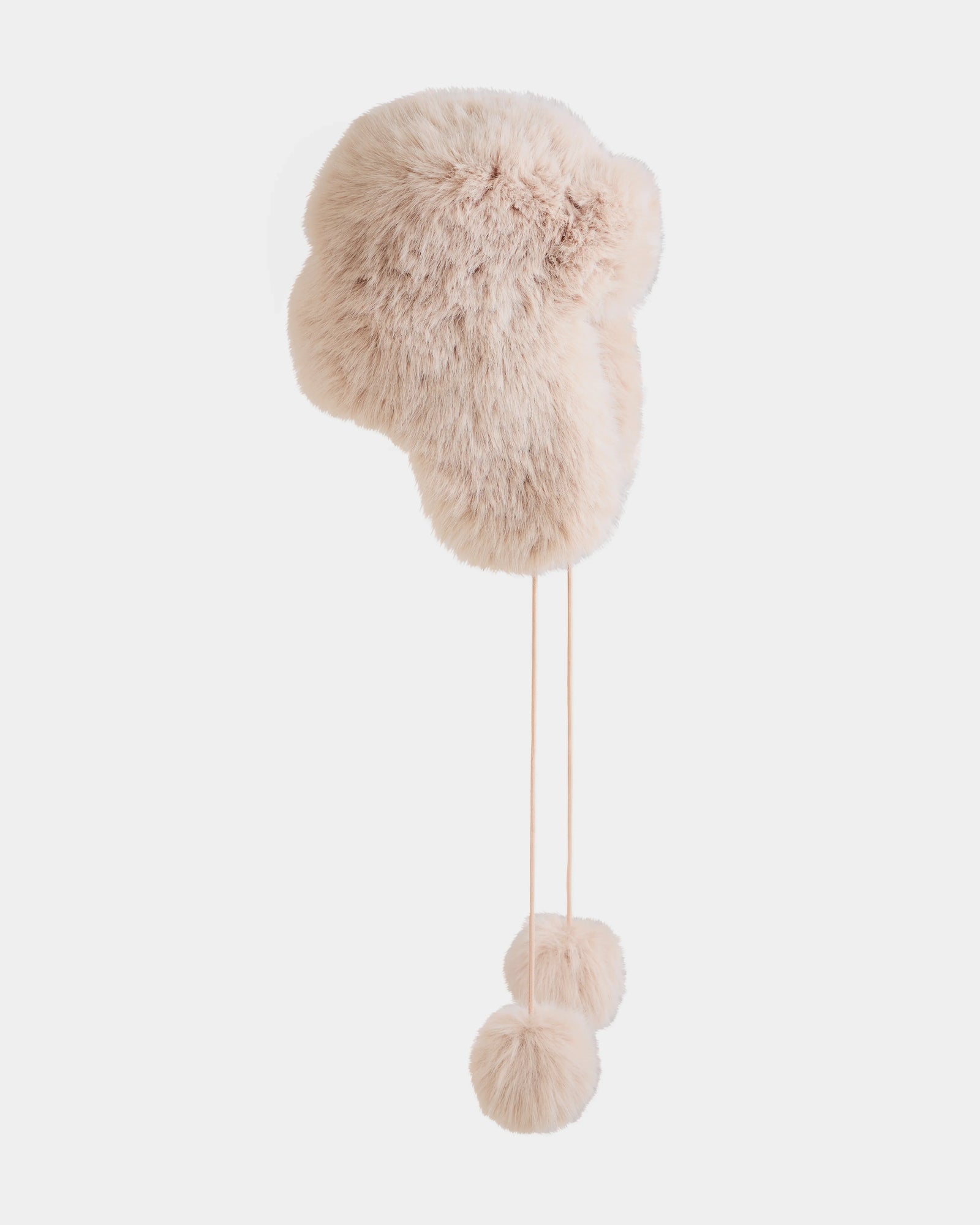 The DEMI - L425539 Vanilla by Rudsak is a light beige faux-fur aviator hat with ear flaps and long strings finished with fluffy pom-poms, shown against a plain white background.