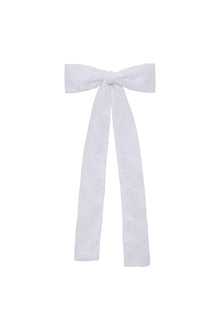 White lace bow ribbon with long trailing ends and textured floral pattern.