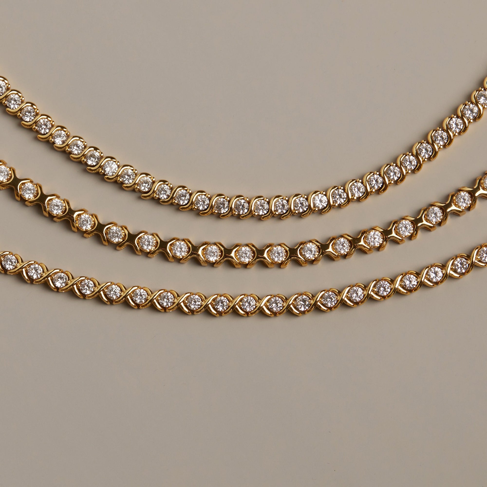 Flatlay Model. Gold necklaces with diamond accents on a beige background