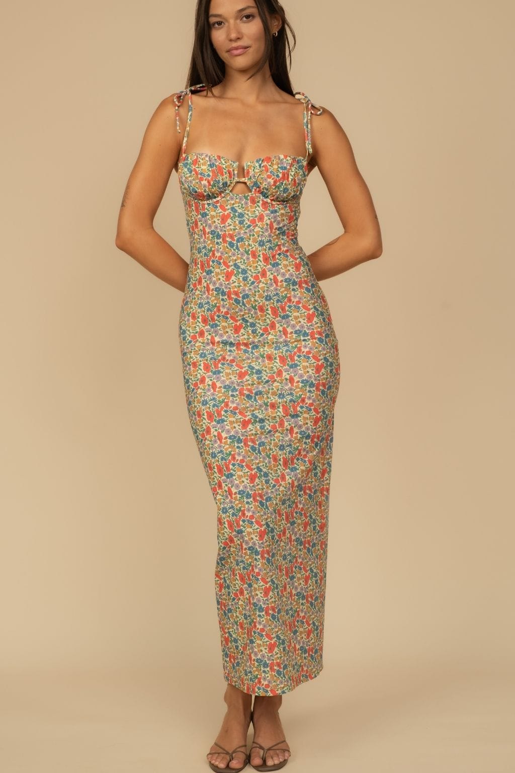 Long slip dress with multicolored floral print, sweetheart neckline, adjustable straps, and cutout detail at bust.