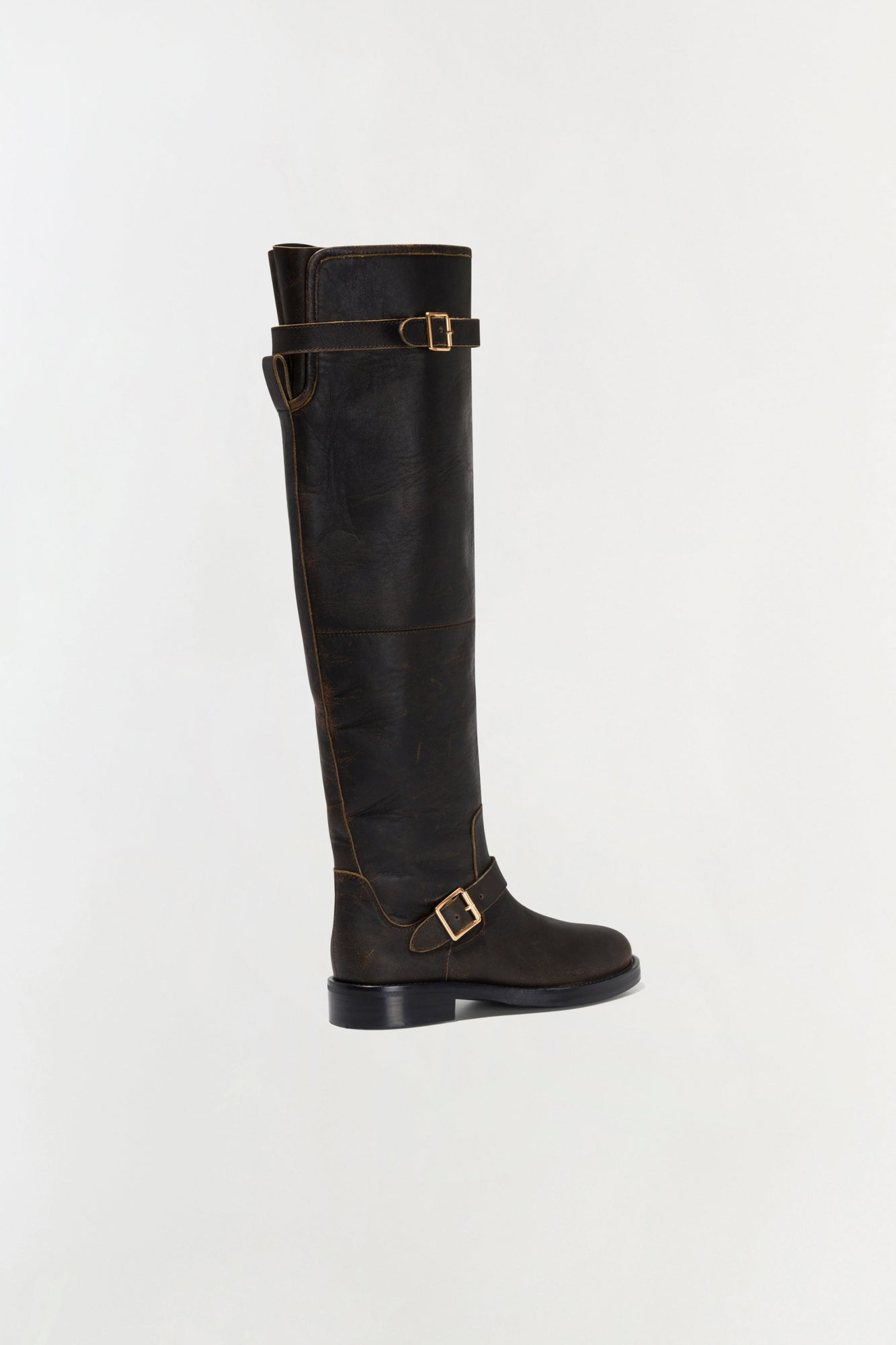 Black leather over-the-knee boot with gold buckle straps and contrasting stitching detail.