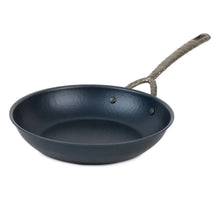 carbon steel frying pan with textured metal handle on white background