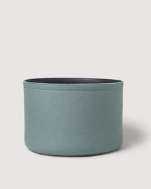 A light green, round Merino wool bin by Graf Lantz with a dark interior, perfect for sustainable organization, set against a plain white background.