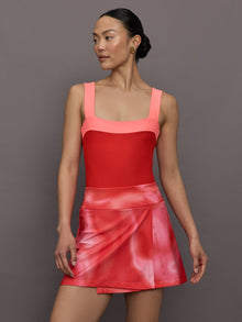 Model wears a high cut one piece square neck bathing suit in red with coral edges. 