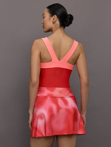 Model wears a high cut one piece square neck bathing suit in red with coral edges. 