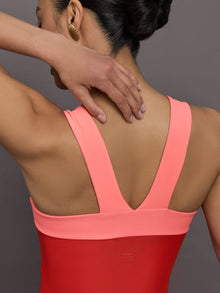 Model wears a high cut one piece square neck bathing suit in red with coral edges. 