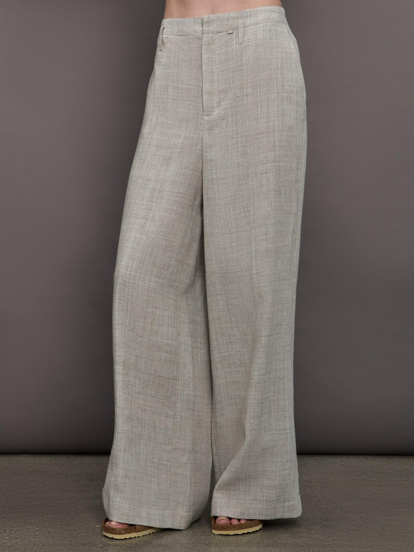 Model wears a pair of gray/taupe oversized wide leg woven work trousers.