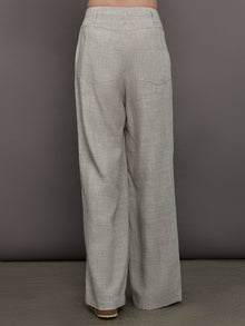 Model wears a pair of gray/taupe oversized wide leg woven work trousers.