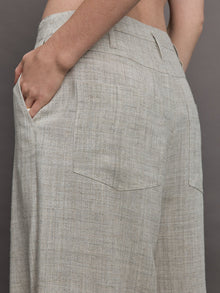 Model wears a pair of gray/taupe oversized wide leg woven work trousers.