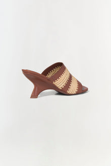 Brown leather mule sandal with natural raffia striped detailing and curved kitten heel.