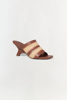 Brown leather mule sandal with natural raffia striped upper and curved heel.