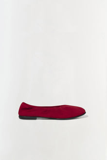 Burgundy suede ballet flat with black sole, shown in profile view.