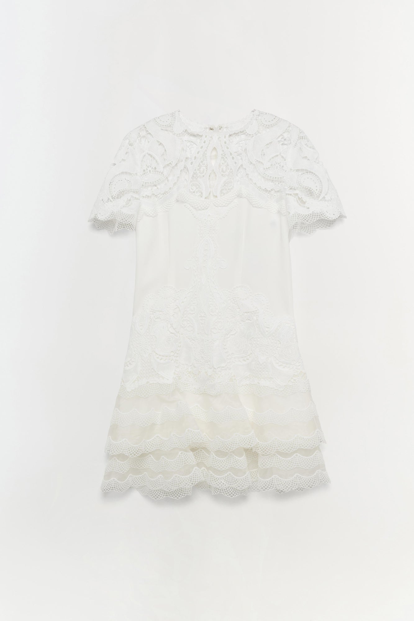 White lace short-sleeve dress with paisley pattern and tiered lace hem detail.