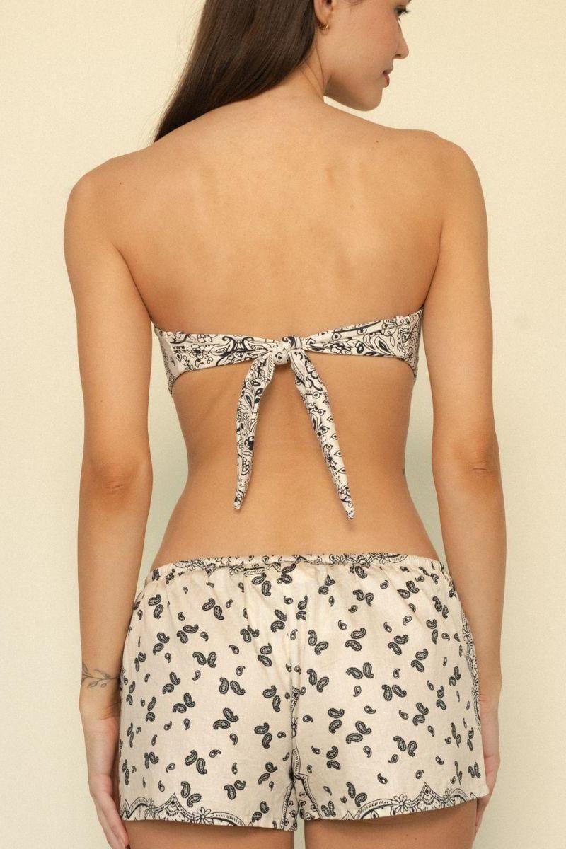 Bandeau bikini top with cream and black paisley print, tie-back closure, shown from rear view on model.