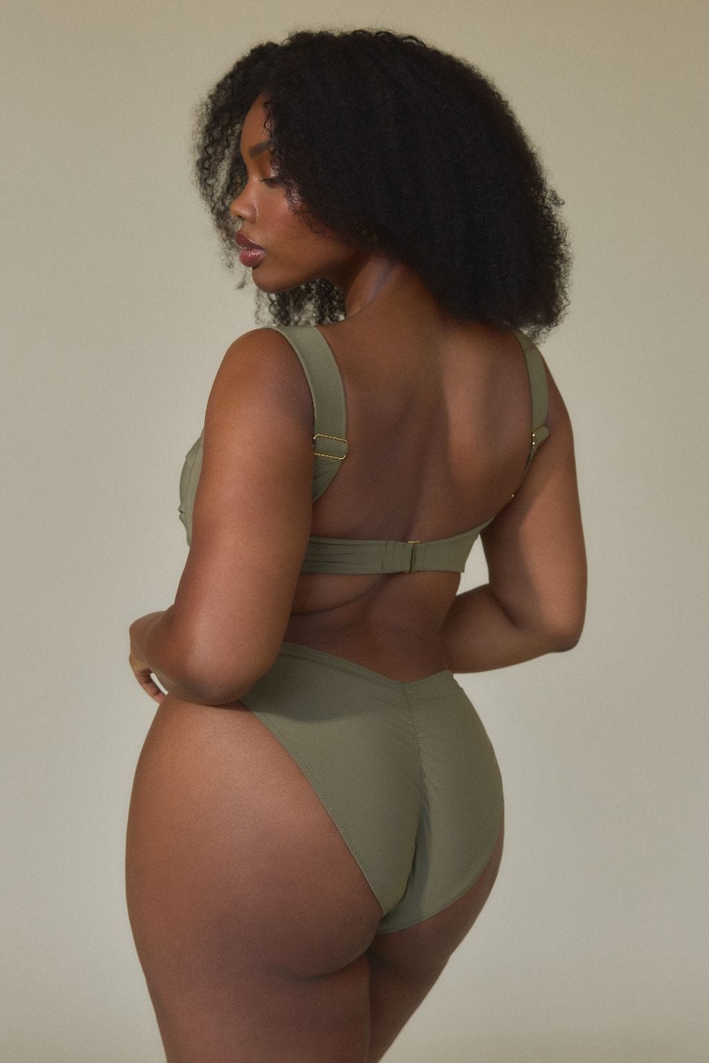 Khaki bikini bottom with zig-zag stitching detail, shown from back view on model.