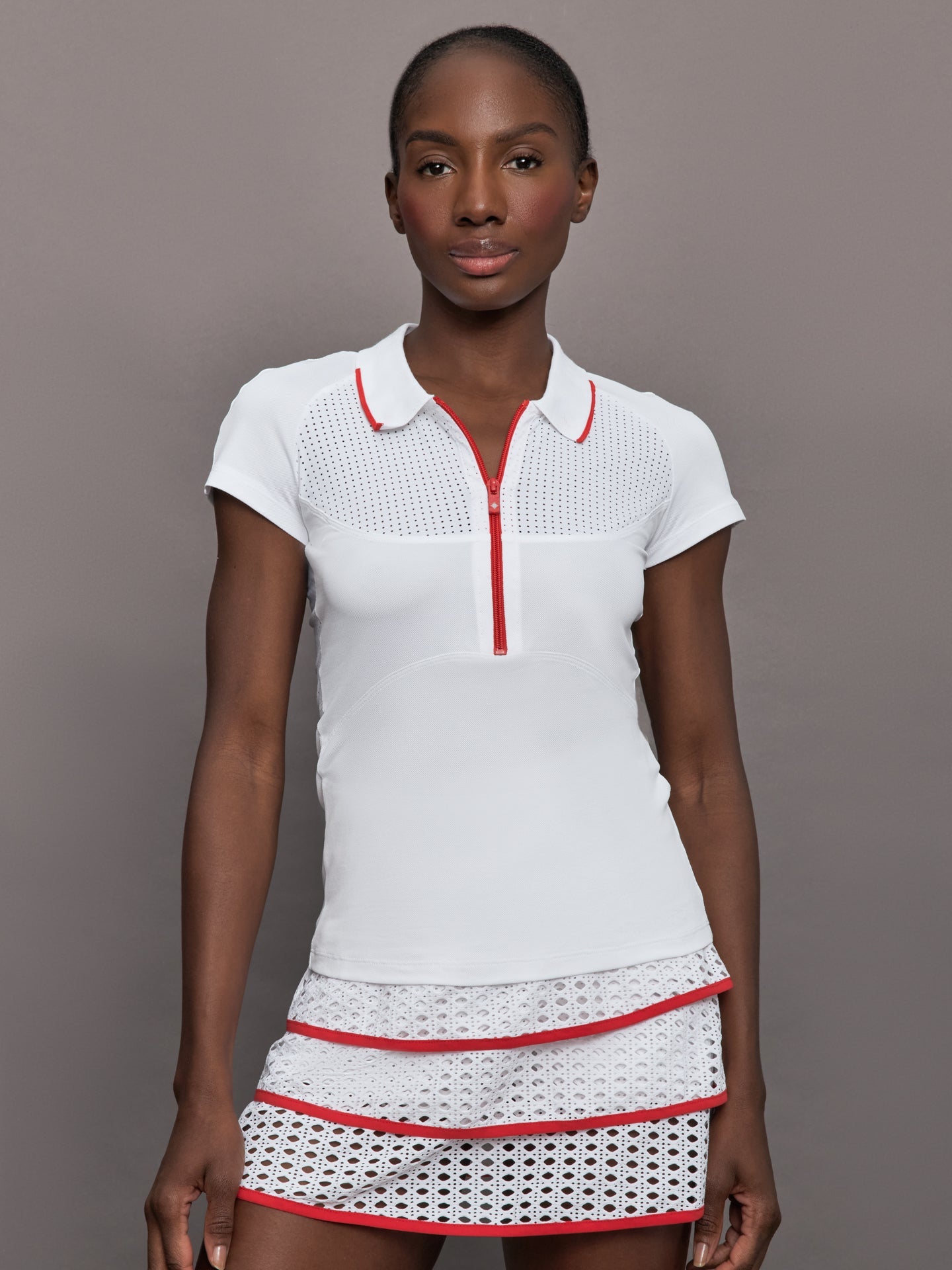 Model wears a mesh short sleeved lightweight tennis polo with red detailing.