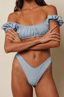 Light blue denim bikini bottom with high-cut legs and textured stitching detail.