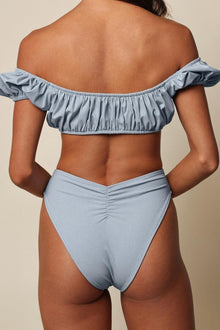 Light blue denim bikini bottom with ruched side detail and high-waisted cut.