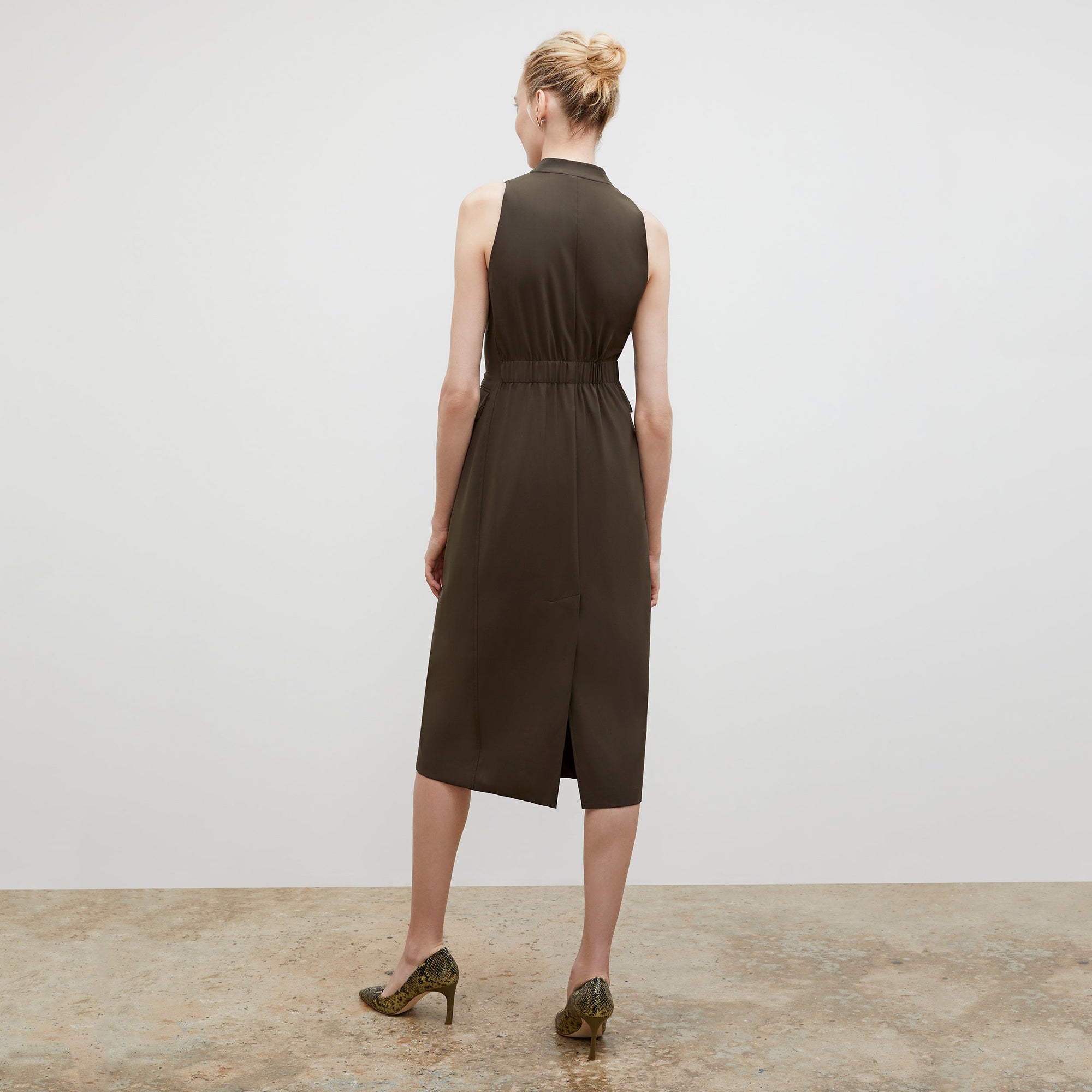 Back image of a woman wearing the Cassandra dress in origamitech in olive | Exclude