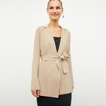 Front image of a woman standing wearing the Merritt jardigan in latte | Exclude