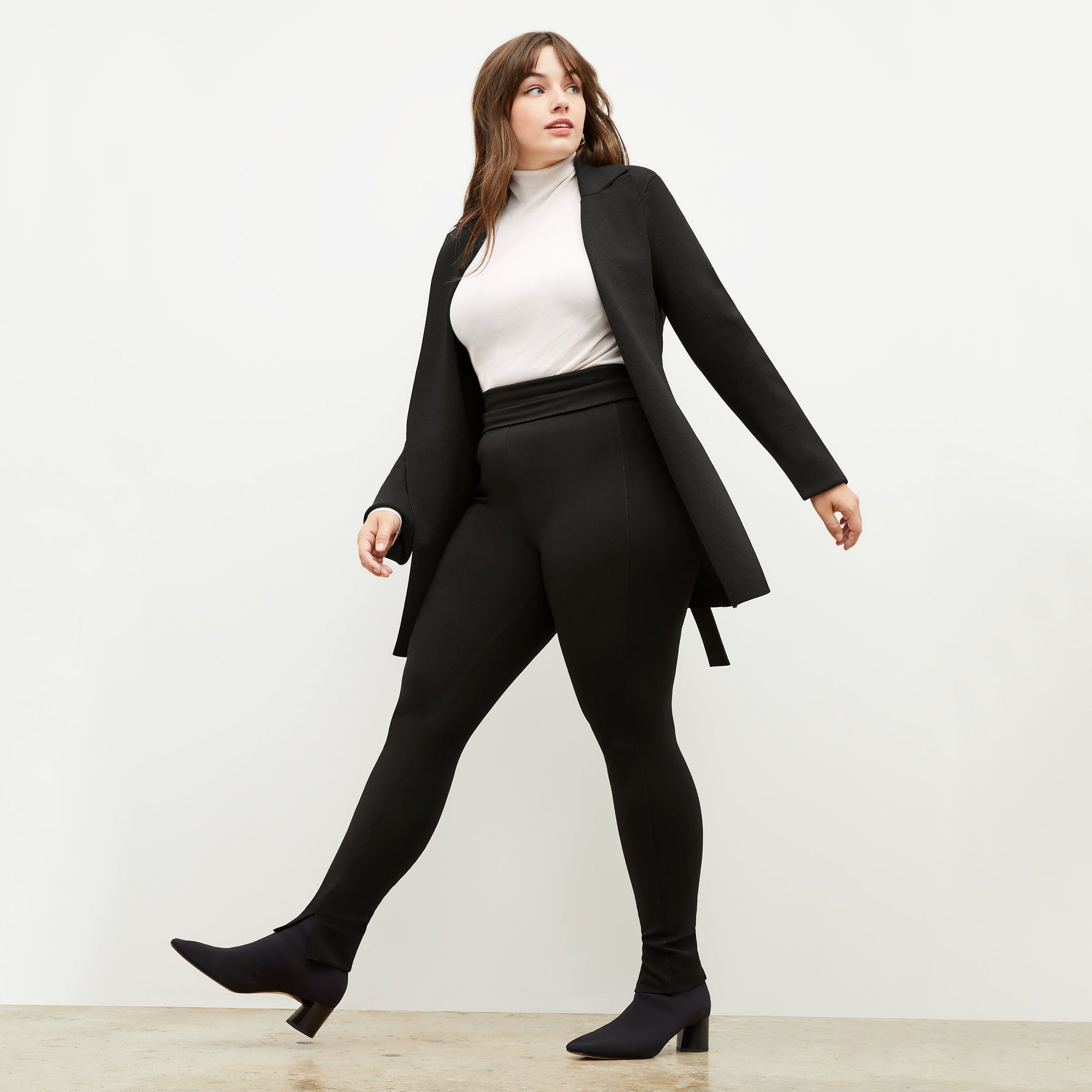 Front image of a woman standing wearing the axam top in ivory | Exclude