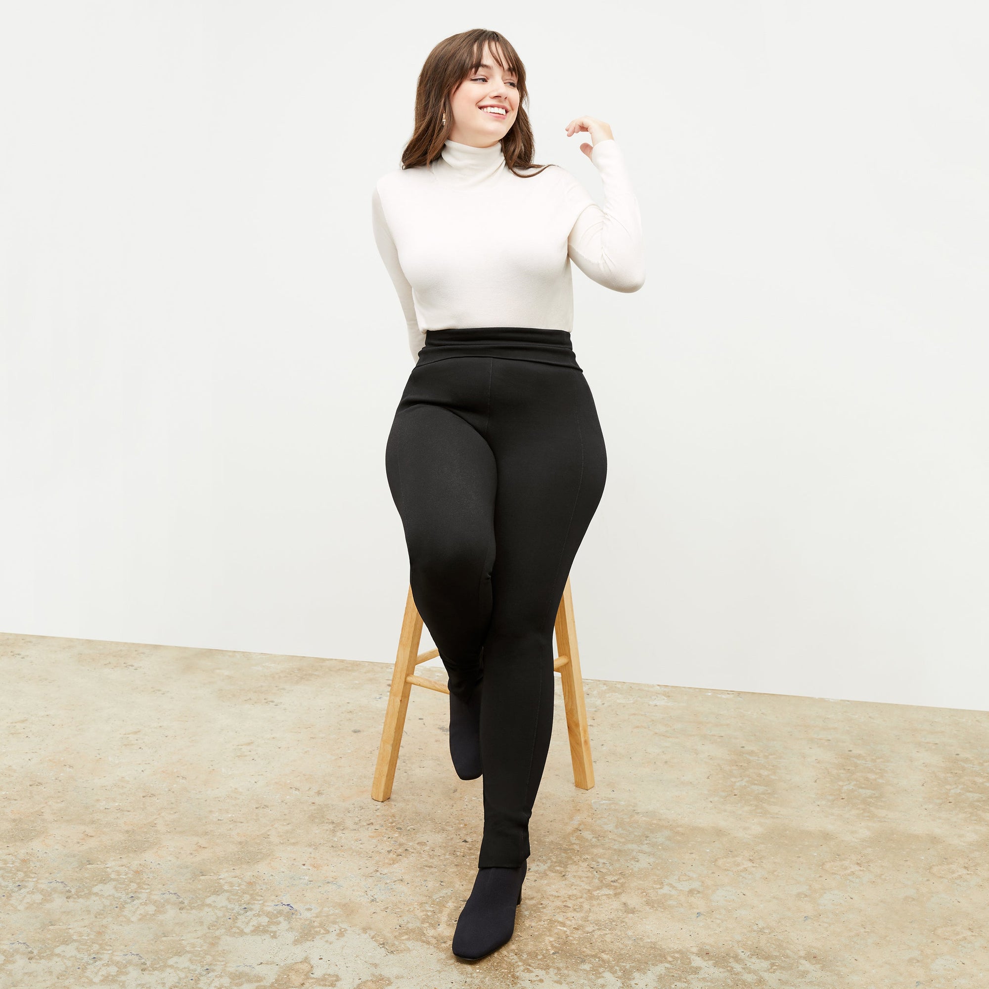 Front image of a woman standing wearing the axam top in ivory | Exclude